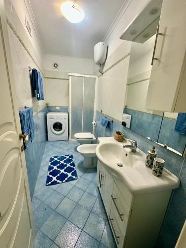 a bathroom with a sink and a toilet and a washing machine at Capri Joy Apartments in Capri