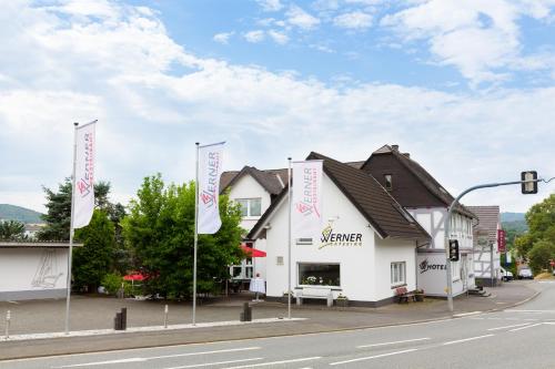 a building on the side of a street with flags at Hotel Werner in Mornshausen