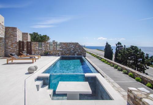 a swimming pool on the side of a house at Pnoe Villas Syros in Megas Yialos-Nites