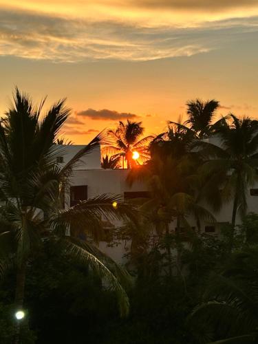 a sunset with palm trees in front of a building at Oceanfront Retreat in Casablanca in Same