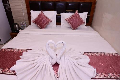 two swans wrapped in towels sitting on a bed at Shri Ram Lalla International in Ayodhya