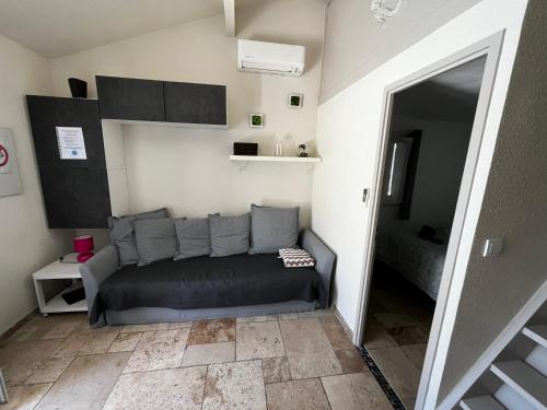a living room with a couch in a room at Havre de paix aux portes de la Provence Verte - Hameau des Pins 101 in Forcalqueiret