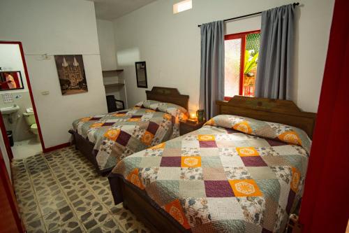 a bedroom with two beds and a window at Hotel La Casona in Jardin