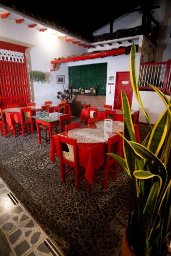 a restaurant with red tables and chairs in a room at Hotel La Casona in Jardin