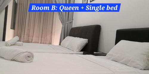two beds in a bedroom with a sign that reads room b queen single bed at M City Ampang KLCC Lake view Pool in Kuala Lumpur