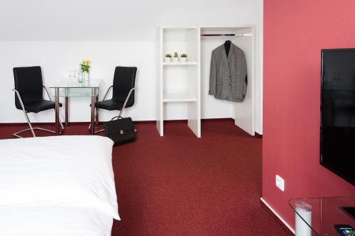 a bedroom with a bed and a table and chairs at Hotel Werner in Mornshausen