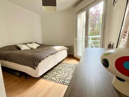 une chambre avec un lit et une grande fenêtre dans l'établissement Large apartment in Old Lille, balcony, secure parking, à Lille