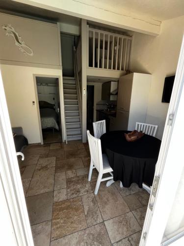 a room with a table and chairs and a staircase at Havre de paix aux portes de la Provence Verte - Hameau des Pins 101 in Forcalqueiret