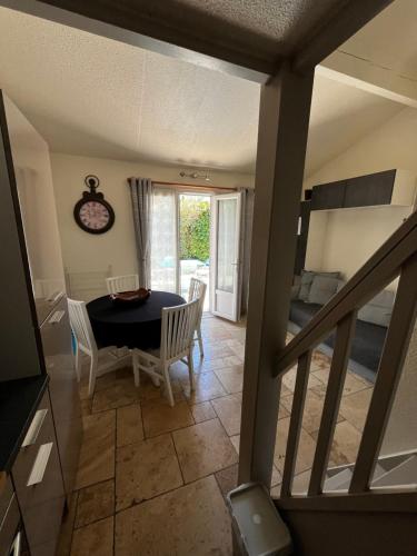 a dining room with a table and chairs and a balcony at Havre de paix aux portes de la Provence Verte - Hameau des Pins 101 in Forcalqueiret