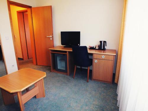 a room with a desk with a computer and a chair at Werrapark Resort Hotel Frankenblick in Masserberg