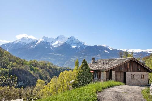 a house on a hill with mountains in the background at Eun Tchì Vo - Gignod in Gignod