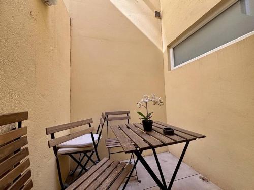 une table en bois avec deux chaises et une table avec des fleurs. dans l'établissement Nice Signature Delille, à Nice