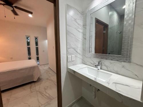 un bagno con lavandino, specchio e letto di Mima's Village Cozumel a Cozumel