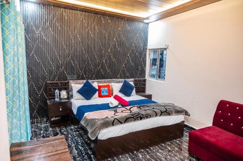 a bedroom with a bed and a red chair at Vasantviharinn 500 meter from ram mandir in Ayodhya