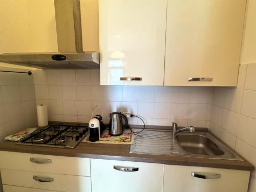 a kitchen counter with a sink and a stove at The Star - Apartment with Lake View in Colonno