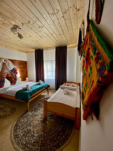 a large room with two beds and a rug at Casa Leca in Breb