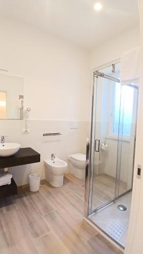a bathroom with a glass shower and two toilets at Leonardo Rooms in Pompei