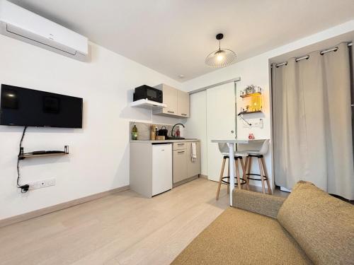 un salon avec un canapé et une petite cuisine dans l'établissement Studio l'Evasion - Clim - Valence, à Valence