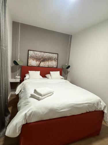 a bedroom with a red bed with white sheets at New studio centre in Brussels