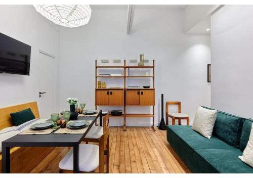 - un salon avec une table et un canapé vert dans l'établissement Apartment in the center of Paris by Studio prestige, à Paris