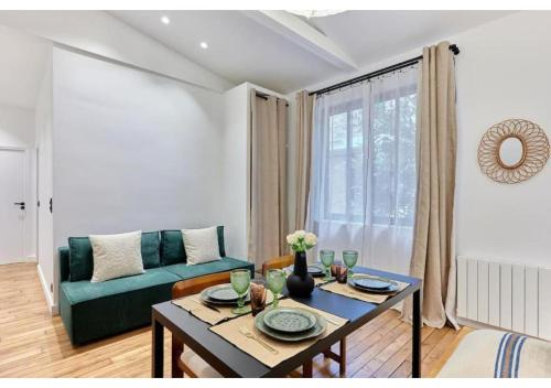 un salon avec un canapé vert et une table dans l'établissement Apartment in the center of Paris by Studio prestige, à Paris