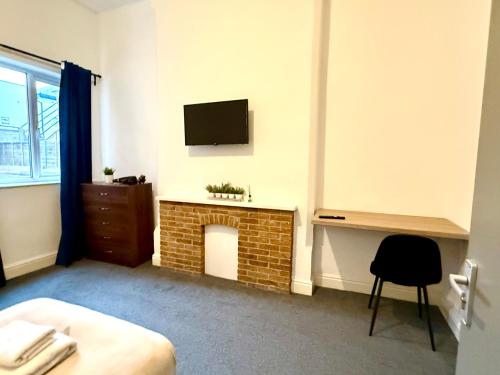 a bedroom with a fireplace and a tv on the wall at Brand New Lovely Flats by the Forest Tram Stop in Nottingham in Nottingham