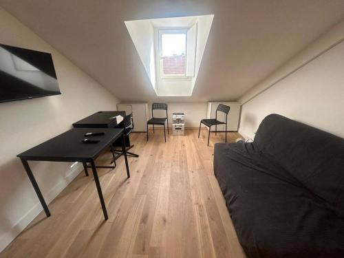 Cette chambre mansardée comprend un bureau et des chaises. dans l'établissement Nice Signature Assalit Studio, à Nice