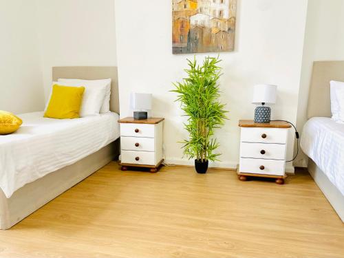 a bedroom with two beds and two night stands at Brand New Lovely Flats by the Forest Tram Stop in Nottingham in Nottingham