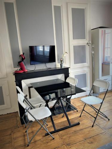 un piano noir avec trois chaises et une télévision dans l'établissement STUDIO double 21 centre de LIMOGES WIFI, à Limoges