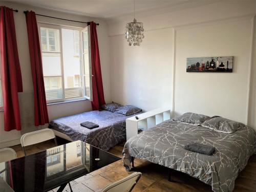 a room with two beds and a glass table at STUDIO double 21 centre de LIMOGES WIFI in Limoges