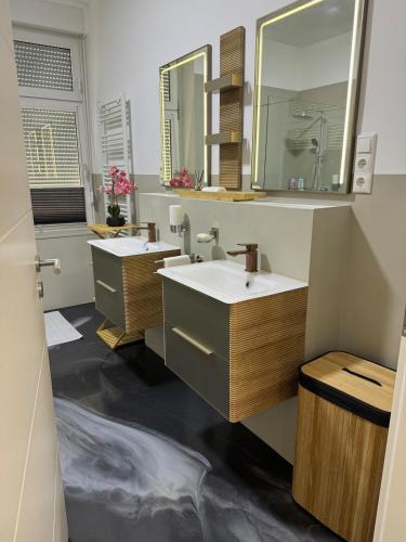 a bathroom with two sinks and a mirror at Mahesars Home in Gevelsberg