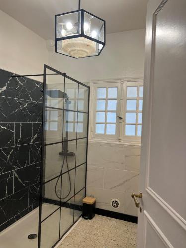 La salle de bains est pourvue d'une douche et d'un lustre. dans l'établissement Castle like retreat next to the Dordogne River, à Argentat