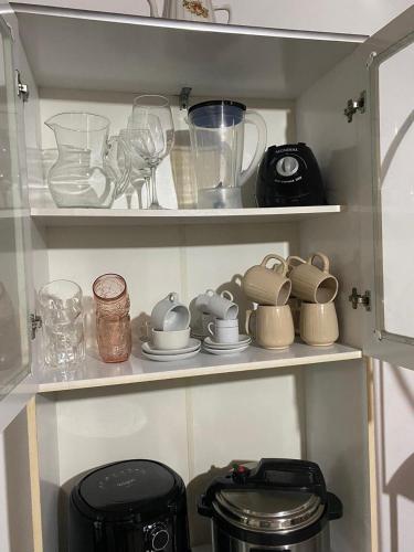 a cupboard filled with lots of kitchen utensils at Cantinho do sossego in Campos do Jordão
