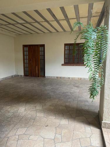 an empty room with two doors and a plant at Cantinho do sossego in Campos do Jordão