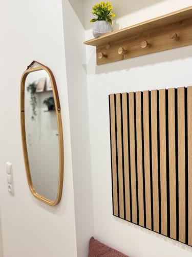 a mirror on a wall next to a shelf at Mahesars Home in Gevelsberg