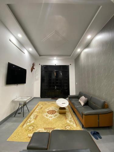 a living room with a couch and a tv at MUBEE Homestay in Hue