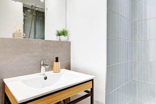 une salle de bain avec un lavabo et un miroir dans l'établissement Eiffel résidence Simone, à Paris
