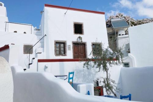 a white building with a brown door on it at The Commander's House in Emporio Santorini