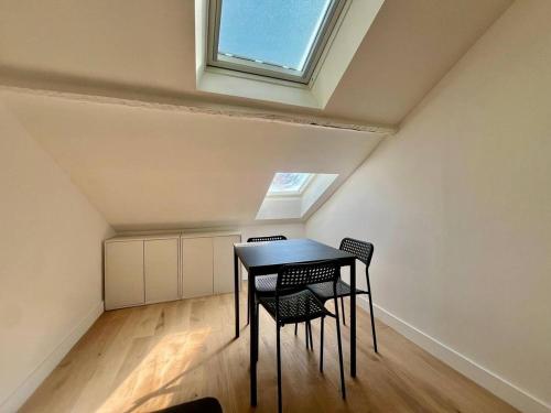 une table et des chaises dans une pièce avec une fenêtre dans l'établissement Nice Signature Assalit 2P, à Nice