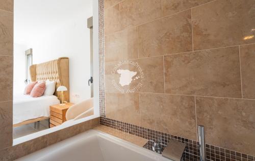 a bathroom with a tub and a bedroom with a bed at CostaBlancaDreams Casa con Vista in Calpe in Empedrola