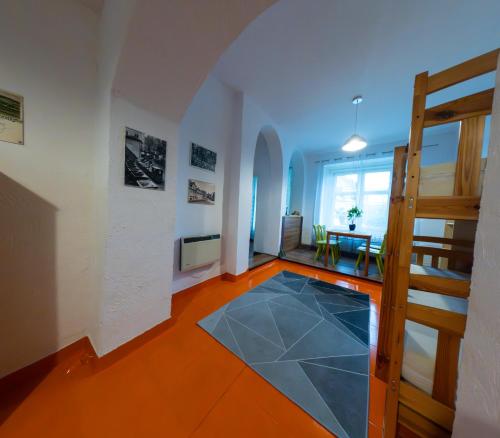 ein Wohnzimmer mit einer Treppe und Fliesenboden in der Unterkunft Loft w centrum Złotego Stoku in Złoty Stok