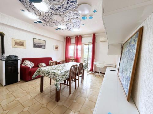 a living room with a table and a red couch at Casa Romita 9 - ArgonautiVacanze in Porto Azzurro