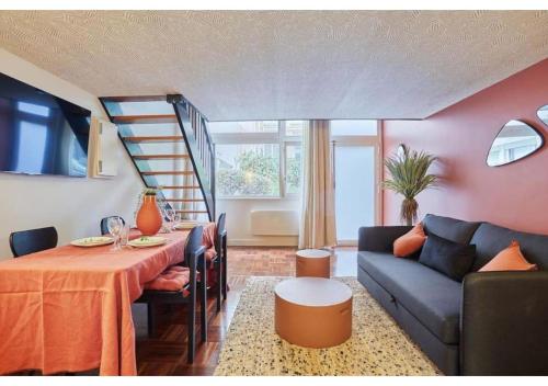 un salon avec une table et un canapé dans l'établissement Apartment Le Marais Place des Vosges by Studio Prestige, à Paris