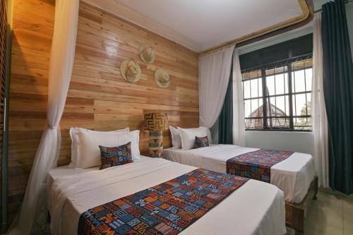 a bedroom with two beds and a window at Aqueduct 1359 Hotel Apartments in Kampala