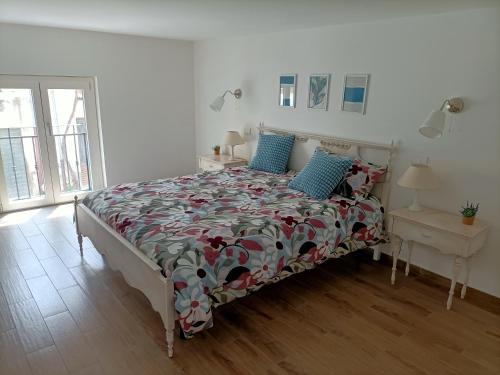 una camera da letto con un letto con copriletto floreale e cuscini blu di Dimora Anna a San Giacomo degli Schiavoni