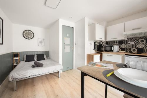 Il comprend une chambre avec un lit et une cuisine avec un évier. dans l'établissement Studio moderne - proximité gare et espace extérieur, à Toulouse
