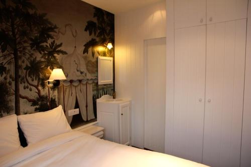 - une chambre avec un lit et une grande peinture murale dans l'établissement L'Epicentre, à Bruxelles