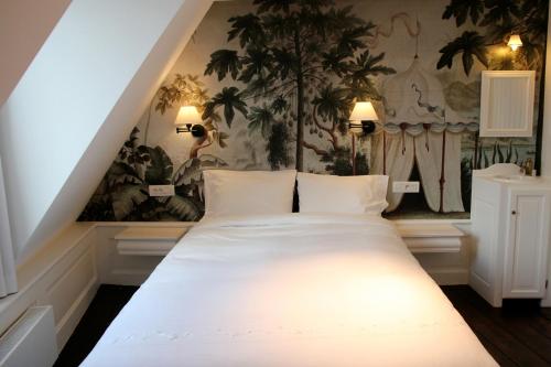 a white bed in a room with a wall at L'Epicentre in Brussels