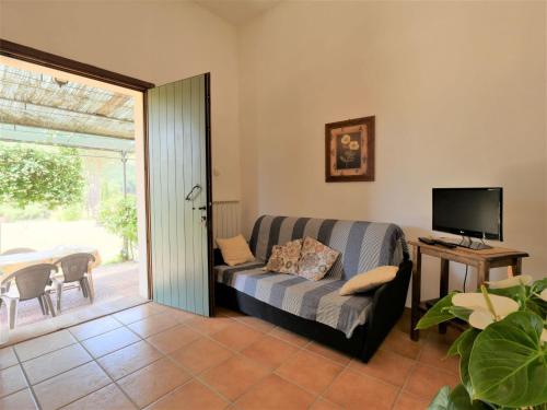 a living room with a couch and a television at Holiday Home Gaia by Interhome in Sticciano