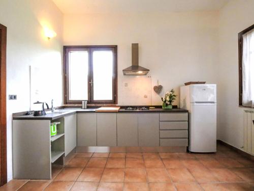 a kitchen with a white refrigerator and a sink at Holiday Home Gaia by Interhome in Sticciano